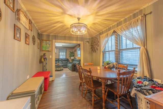 dining area featuring a notable chandelier, crown molding, and wood-type flooring