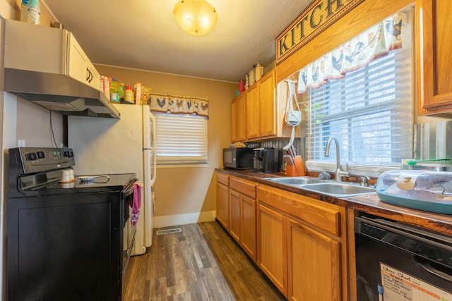 kitchen with sink, black appliances, dark hardwood / wood-style floors, and exhaust hood