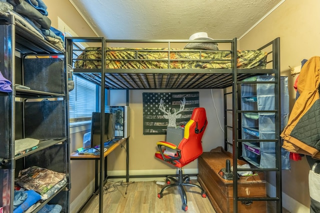 bedroom with wood-type flooring and a textured ceiling