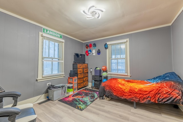 bedroom featuring crown molding and light hardwood / wood-style floors