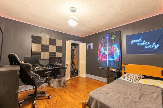 bedroom with light hardwood / wood-style floors and a closet