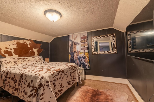 carpeted bedroom featuring vaulted ceiling, a textured ceiling, and wood walls