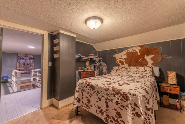 carpeted bedroom with lofted ceiling and a textured ceiling