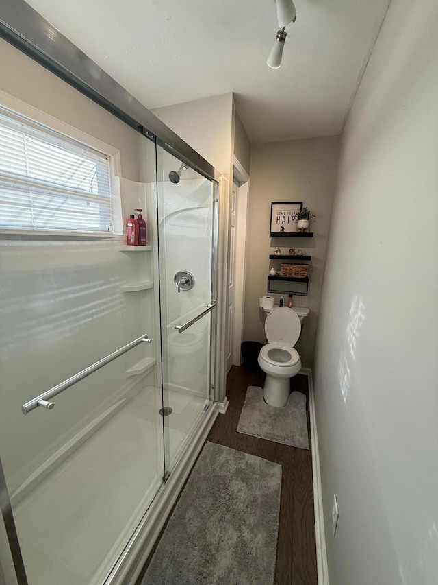 bathroom with toilet, an enclosed shower, and hardwood / wood-style floors