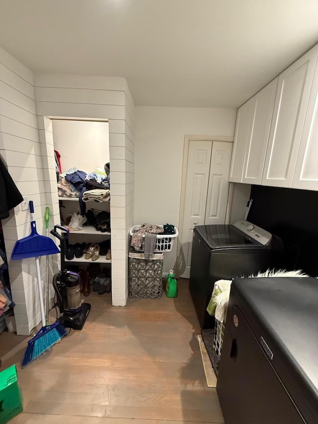 washroom with cabinets, separate washer and dryer, and light hardwood / wood-style floors