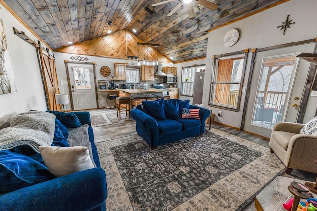 living room with lofted ceiling, ceiling fan, a barn door, wooden ceiling, and light hardwood / wood-style flooring