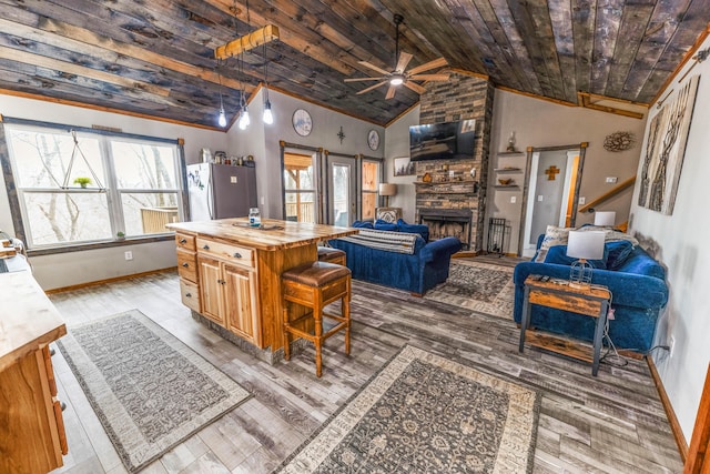 living room featuring wood ceiling, ceiling fan, baseboards, and a fireplace