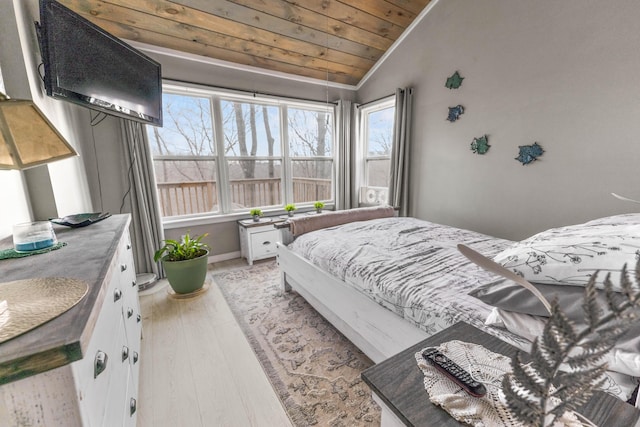 bedroom with wood ceiling, vaulted ceiling, light wood finished floors, and baseboards