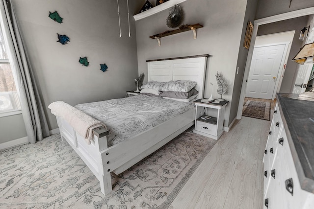 bedroom with light wood-type flooring and baseboards
