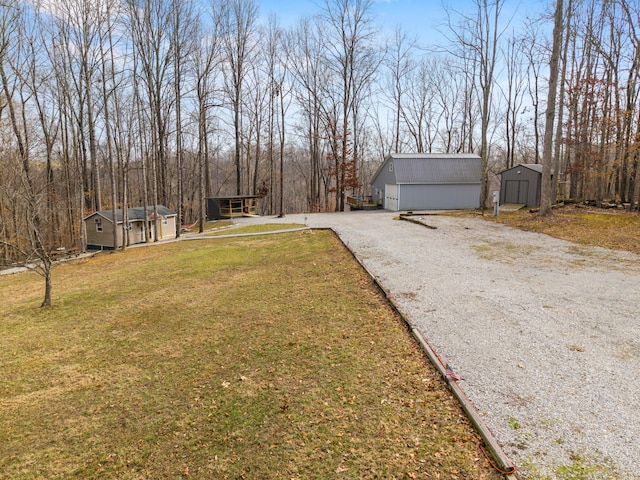 view of yard with an outdoor structure, a storage unit, and gravel driveway