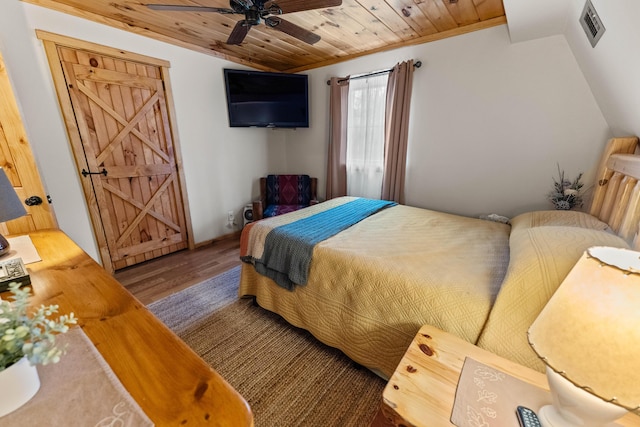 bedroom with vaulted ceiling, wood finished floors, visible vents, and wood ceiling