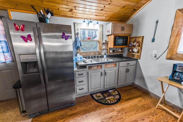 kitchen featuring stainless steel refrigerator with ice dispenser, sink, gray cabinetry, wood ceiling, and black microwave