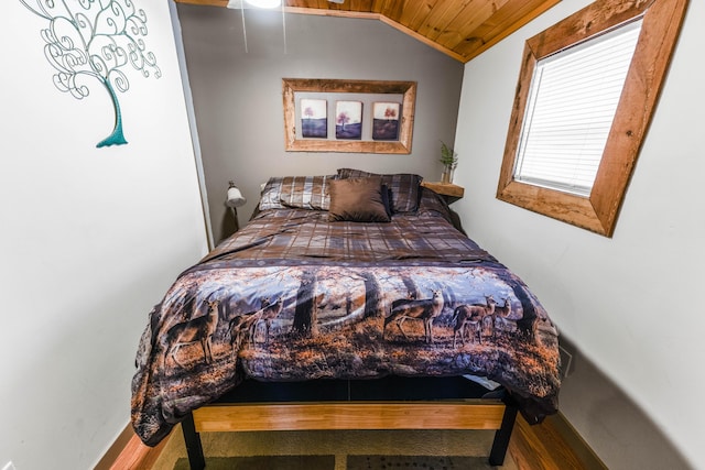 bedroom featuring baseboards, lofted ceiling, and wood ceiling