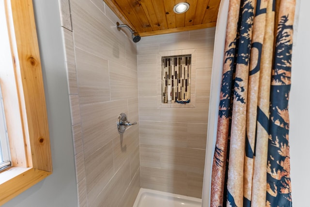 bathroom with a tile shower and wood ceiling