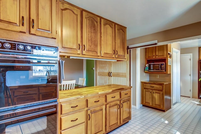 228 Jolly Ridge Rd, Richmond, KY 40475 - kitchen with stainless steel microwave, butcher block counters, and brown cabinetry