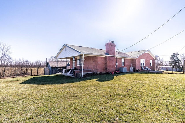 228 Jolly Ridge Rd, Richmond, KY 40475 - view of home's exterior with central AC, a lawn, brick siding, and metal roof