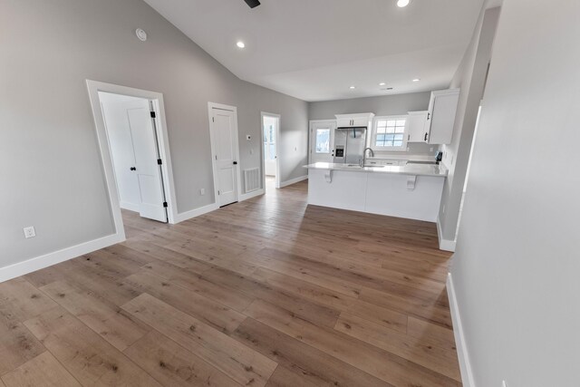 foyer entrance with vaulted ceiling, ceiling fan, and light hardwood / wood-style floors