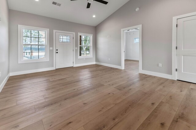 interior space with ceiling fan, lofted ceiling, and light hardwood / wood-style floors