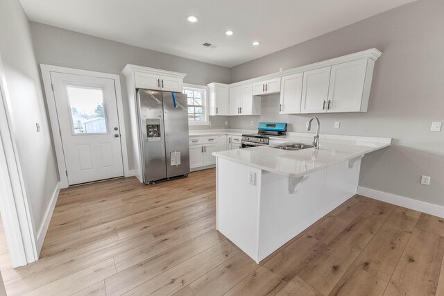 kitchen featuring white cabinetry, light wood-type flooring, electric range, dishwashing machine, and kitchen peninsula