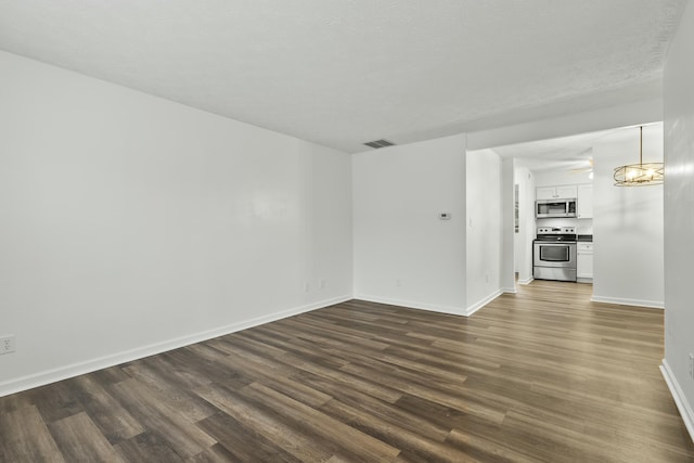 empty room featuring dark wood-type flooring and a textured ceiling