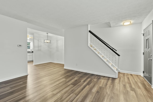 unfurnished living room featuring hardwood / wood-style floors and a textured ceiling