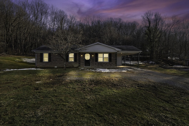 ranch-style home with a carport and a yard