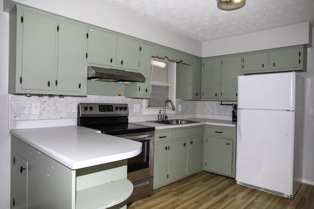 kitchen with sink, white refrigerator, electric range, light hardwood / wood-style floors, and a textured ceiling