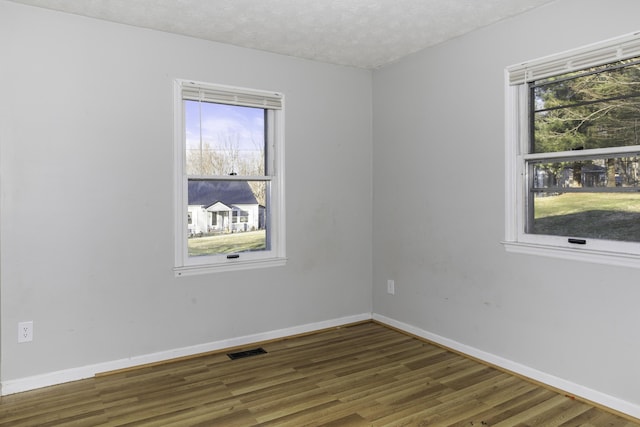 empty room featuring dark wood-type flooring and a textured ceiling