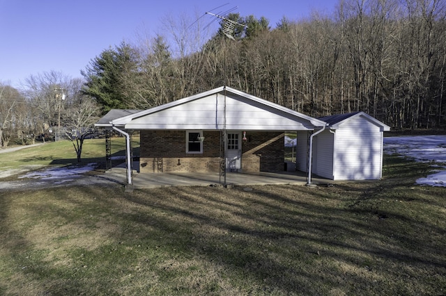 rear view of house featuring a carport and a yard