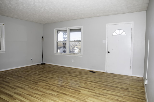 entrance foyer featuring a textured ceiling and light wood-type flooring