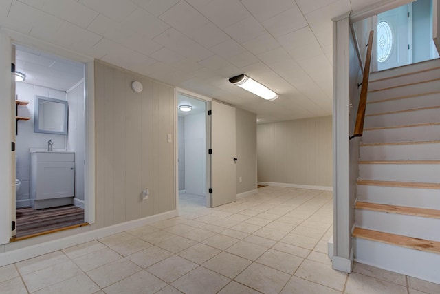 basement with light tile patterned flooring and sink