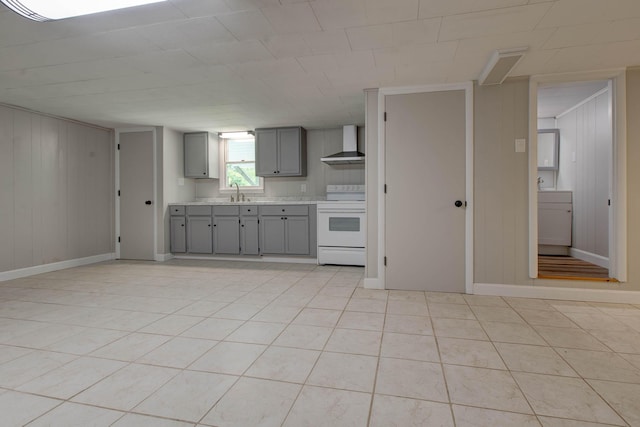 kitchen featuring gray cabinets, light tile patterned flooring, electric stove, sink, and wall chimney exhaust hood