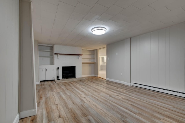 unfurnished living room with built in features, a fireplace, light hardwood / wood-style flooring, and a baseboard heating unit