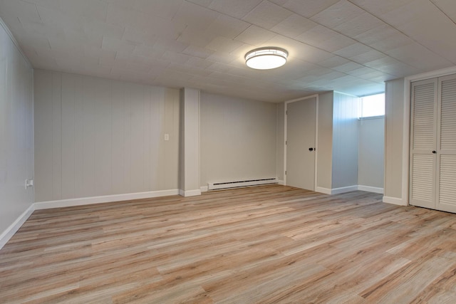 basement with light hardwood / wood-style flooring and a baseboard radiator