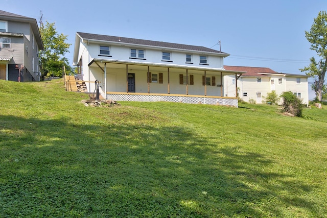 back of house featuring covered porch and a lawn