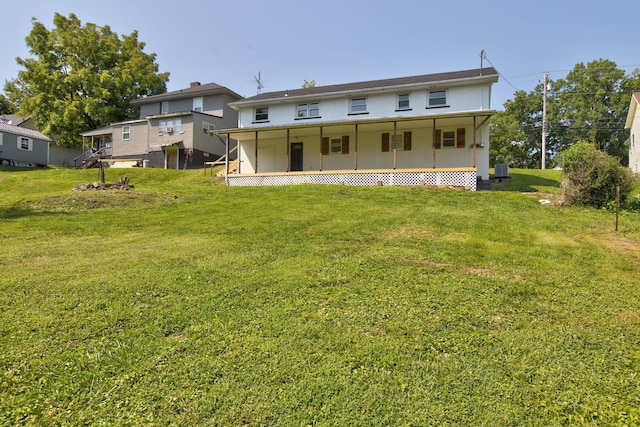 rear view of property with cooling unit, a yard, and covered porch