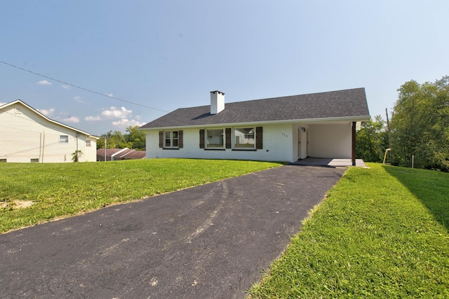 ranch-style house featuring a carport and a front lawn