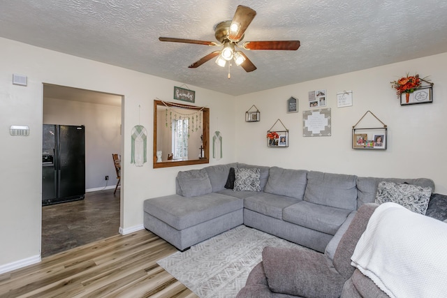 living room featuring hardwood / wood-style flooring, a textured ceiling, and ceiling fan