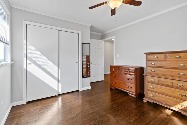 unfurnished bedroom featuring crown molding, dark hardwood / wood-style floors, ceiling fan, and a closet