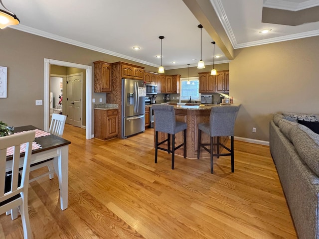 kitchen with light hardwood / wood-style flooring, a breakfast bar area, stainless steel appliances, light stone counters, and ornamental molding