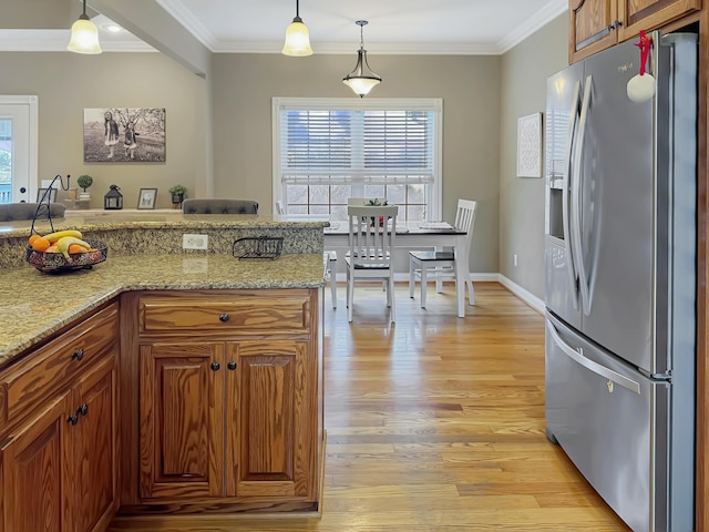 kitchen with ornamental molding, light stone countertops, pendant lighting, and stainless steel fridge with ice dispenser