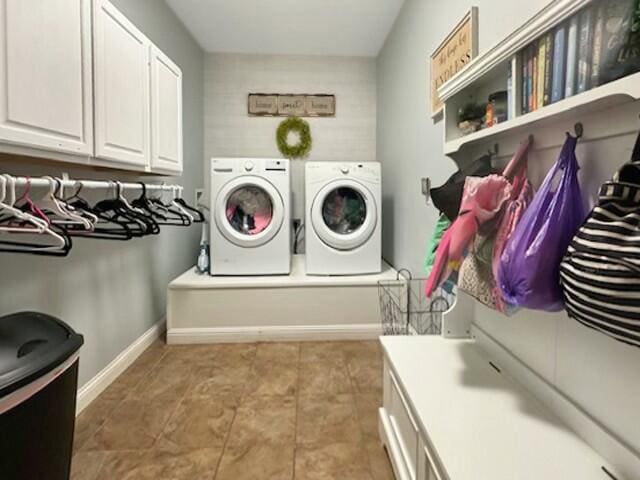 clothes washing area featuring cabinets and washing machine and dryer