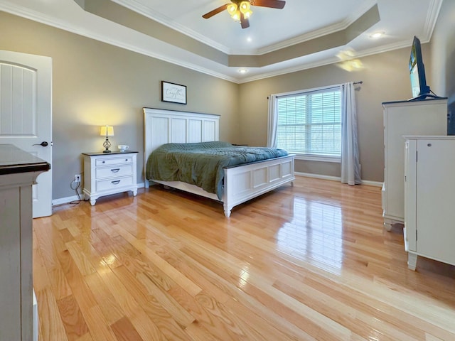 unfurnished bedroom with ceiling fan, ornamental molding, a raised ceiling, and light hardwood / wood-style floors