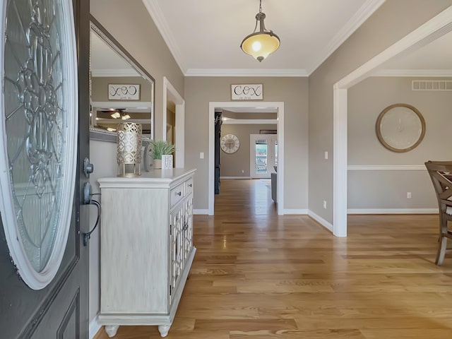 foyer featuring crown molding and light hardwood / wood-style floors