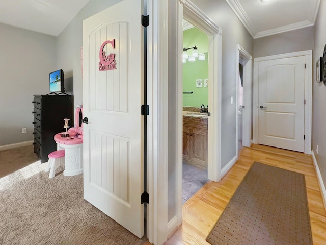 corridor with hardwood / wood-style flooring and ornamental molding