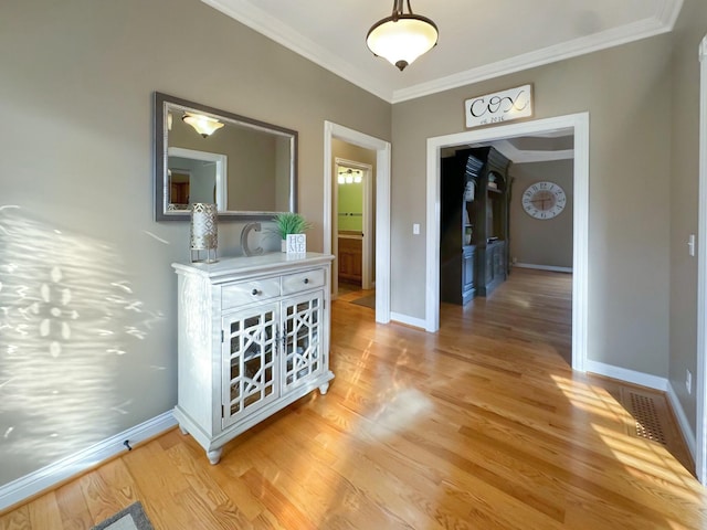 hallway featuring crown molding and light wood-type flooring