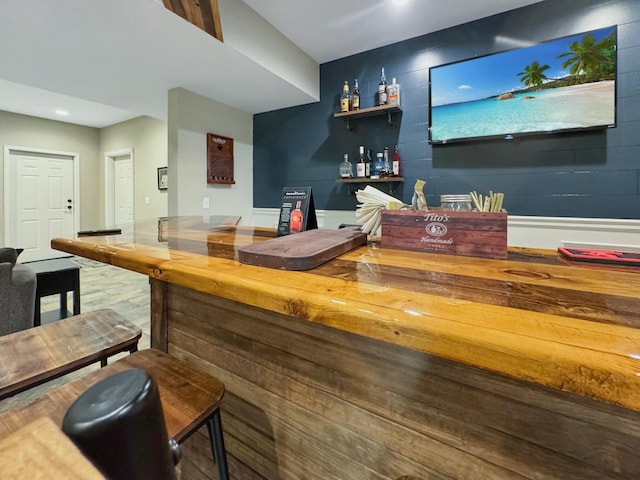 bar featuring butcher block counters and hardwood / wood-style floors