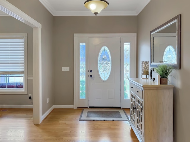 entryway with crown molding and light hardwood / wood-style floors