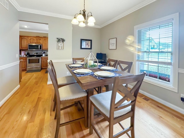 dining area with crown molding, a chandelier, and light wood-type flooring