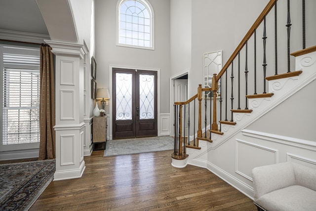 foyer with ornate columns, dark hardwood / wood-style flooring, and french doors